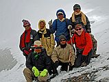 206 Crew On Ridge To Dhampus Pass. Kneeling Gyan Tamang, Pemba Rinji, Jerome Ryan. Standing Nima Dorje,Mingma, Kumar, Tenzin A few minutes after reaching the ridge to Hidden Valley at around 4500m, the trail entered snow. We could see more people descending the snow slopes ahead. Hmm, what to do. The trail plodding though the snow would be much slower, so I was worried that we might not reach Hidden Valley by the time the wind explodes. I decided once again to retreat. Just before we turned around and retreated, I took another team photo. Kneeling down are guide Gyan Tamang, cooks helper Pemba Rinji, and Jerome Ryan. Standing are porters Nima Dorje and Mingma, cook Kumar, and cook helper Tenzin.